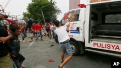 Para demonstran memukul mobil van polisi Filipina setelah menabrak kerumunan demonstran di Manila, Rabu (19/10).