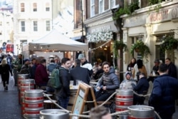 FILE PHOTO: People drink at the terrace of a bar, as the coronavirus disease (COVID-19) restrictions ease, in London, Britain, April 16, 2021. REUTERS/Henry Nicholls/File Photo