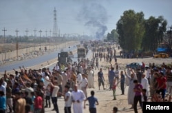 Iraqi people gather on the road as they welcome Iraqi security forces members, who continue to advance in military vehicles in Kirkuk, Iraq, Oct. 16, 2017.