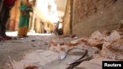 A blood-stained sandal is seen in front of a house, where four Egyptian Shi'ites were killed, in the suburb of Zawiyat Abu Musallem, on the outskirts of Cairo, June 24, 2013.