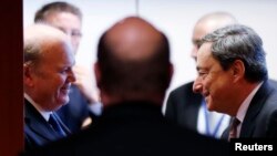 Ireland's Finance Minister Michael Noonan talks to European Central Bank (ECB) President Mario Draghi (R) during an eurozone finance ministers meeting in Brussels, Dec. 9, 2013.
