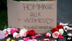 Un cartel que dice "Homenaje a las víctimas. Soy Estrasburgo" y flores recuerdan a las víctimas del reciente ataque en mercado de Estrasburgo, al este de Francia, el miércoles 12 de diciembre de 2018. 