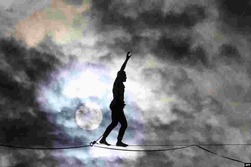 French highliner Nathan Paulin performs on a 70-meter-high slackline spanning 670 meters between the Eiffel Tower and the Theatre National de Chaillot, as part of the 38th European Heritage Days and the launch of the Cultural Olympiad in Paris, France, Sept. 18, 2021.