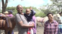 Stanley Dzingai brings his 4-year-old child for regular horse therapy sessions at the Harare site. Nov. 21, 2019. (Columbus Mavhunga/VOA)