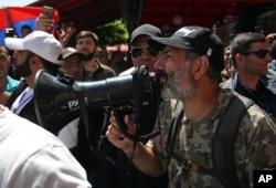 Opposition lawmaker Nikol Pashinian, right, uses a megaphone during a demonstration in Yerevan, May 2, 2018.