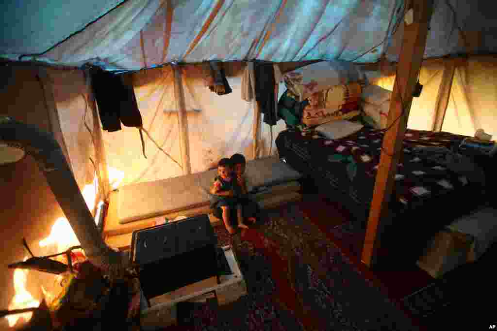 Syrian refugee children inside their tent at a small camp in Ketermaya village, Lebanon, March 14, 2013.