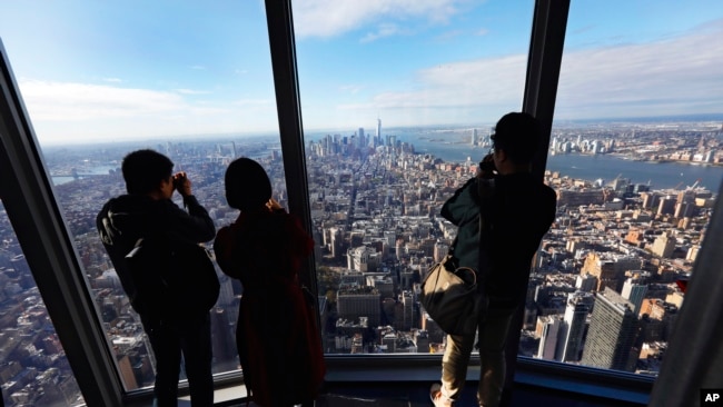 People look at the south view in the 102nd floor Observatory of the Empire State Building, in New York, Thursday, Oct. 10, 2019. (AP Photo/Richard Drew)