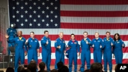 Astronauts, from left, Victor Glover, Michael Hopkins, Robert Behnken, Douglas Hurley, Nicole Mann, Christopher Ferguson, Eric Boe, Josh Cassada and Sunita Williams give a thumbs up to the crowd after NASA announced them as astronauts assigned to crew the