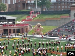 The marching band takes the field at a football game.