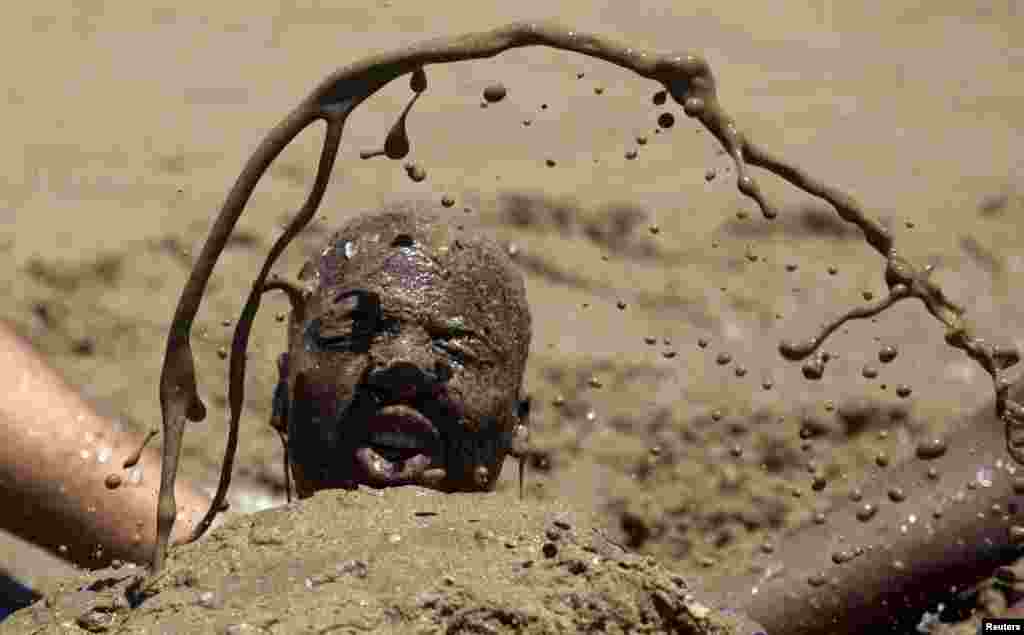 A man gets a sand bath from friends as thousands of people took to the beaches on New Year's Day in Durban, South Africa.