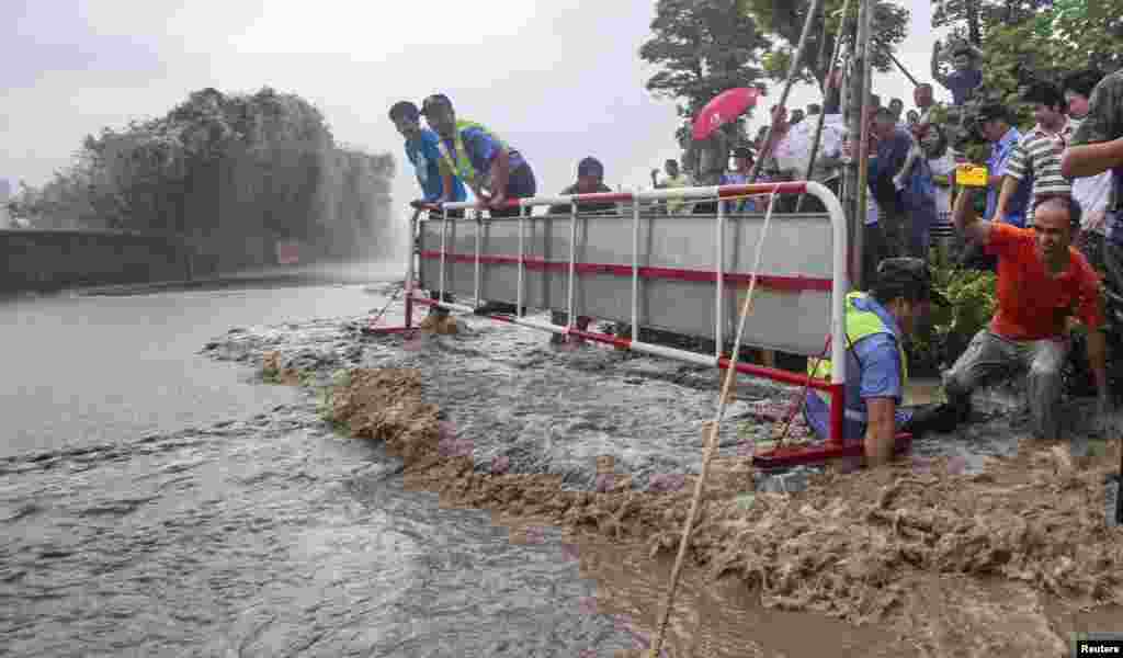 People react after being hit by a tidal wave as Typhoon Usagi approached Hangzhou, Zhejiang province, China, Sept. 21, 2013.