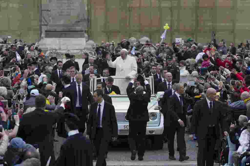Pope Francis is surrounded by his security guards as he arrives for his weekly general audience, held in St. Peter's Square, at the Vatican.