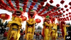 Para penari bersiap menggelar pertunjukan barongsai di Taman Ditan, yang menandai dimulainya perayaan Tahun Baru China di Beijing, Senin (8/2). 