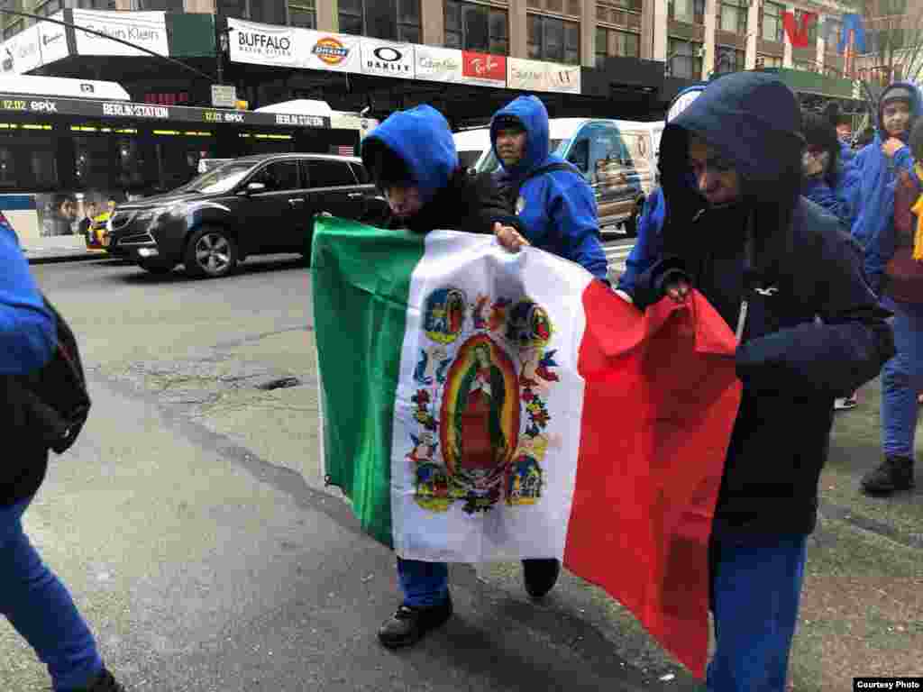 Creyentes sostienen una bandera con los colores de México, donde en el medio, se ve una imagen de la Virgen de Guadalupe, en la Ciudad de Nueva York. Foto: Celia Mendoza- VOA
