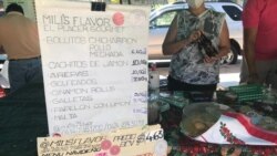 Un puesto en un mercado a cielo abierto muestra los precios en dólares de algunos platos típicos navideños en Caracas.