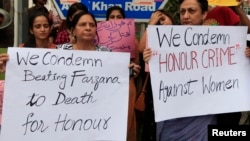 Members of civil society hold placards during a protest against honor killing in Lahore, Pakistan. 