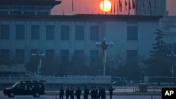 FILE - Chinese men walk on Tiananmen Square, March 5, 2015.