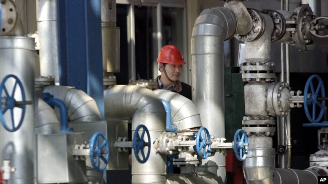 一名中国工人正走过吉林省一个中石油炼油厂的厂区设备。（资料照片）