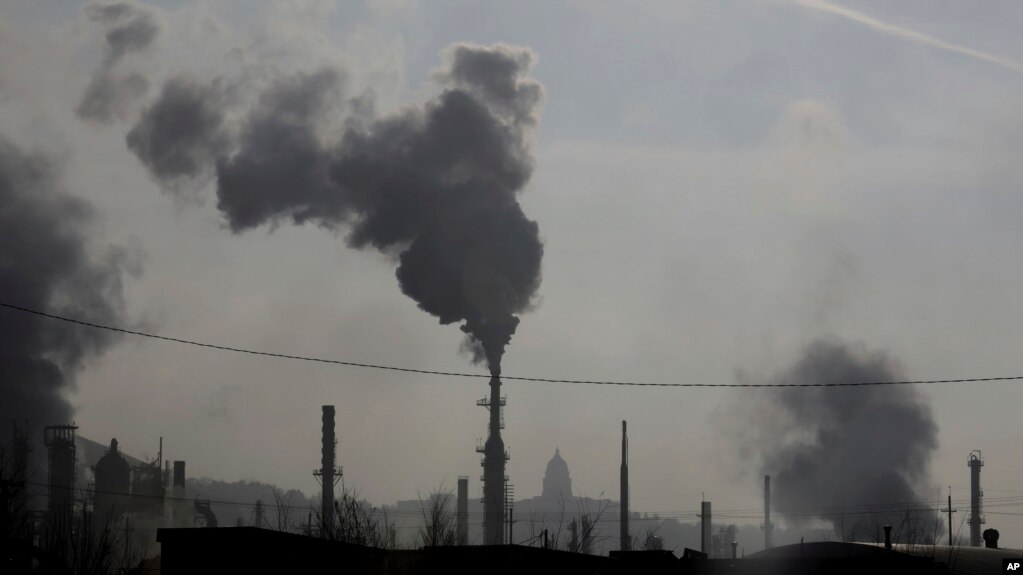 FILE - In this Dec. 10, 2018 photo, smokestacks near an oil refinery are seen in front of the Utah State Capitol as an inversion settles over Salt Lake City. 