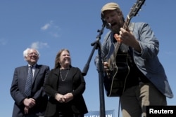 U.S. Democratic presidential candidate Bernie Sanders and his wife, Jane, listen as Guy Forsyth performs "This Land Is Your Land" at a campaign rally in Austin, Texas, Feb. 27, 2016.
