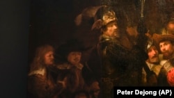 Het linker detail van de Nachtwacht laat zien hoe Rembrandts grootste schilderij werd vergroot met behulp van kunstmatige intelligentie in Amsterdam, Nederland, op woensdag 23 juni 2021.  (AP Foto / Peter Djong)