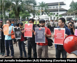 Sejumlah jurnalis mengangkat poster dalam aksi Hari Buruh di Bandung, 1 Mei 2019. Dalam aksinya, mereka menuntut penghapusan kekerasan terhadap awak media. (Foto: Aliansi Jurnalis Independen (AJI) Bandung)