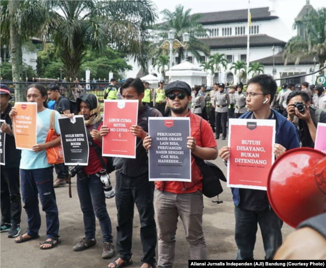 Sejumlah jurnalis mengangkat poster dalam aksi Hari Buruh di Bandung, 1 Mei 2019. Mereka menuntut penghapusan kekerasan terhadap awak media. (Foto: Aliansi Jurnalis Independen (AJI) Bandung)