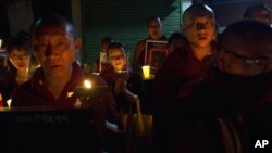 Tibetan exiles participate in a candlelit vigil in Dharmsala, India, Sunday, Sept. 30, 2012.