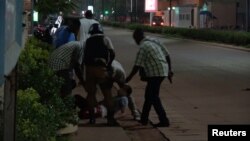 A wounded person is evacuated following an attack by gunmen on a restaurant in Ouagadougou, Burkina Faso, in this still frame taken from video August 13, 2017.