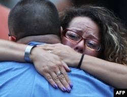 A woman hugs a man during a commemoration ceremony for the victims of the September 11 terrorist attacks at the National September 11 Memorial and Museum in New York City, Sept. 11, 2016.