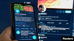 A message from the Twitter communications department confirming the hacking of co-founder and CEO Jack Dorsey's Twitter account and his postings is seen on a mobile phone held in front of Dorsey's twitter feed displayed on a computer screen in this photo 