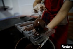 Adriana Pino makes chocolate bars at the +58 Cacao chocolate factory in Caracas, Venezuela, Oct. 6, 2017.