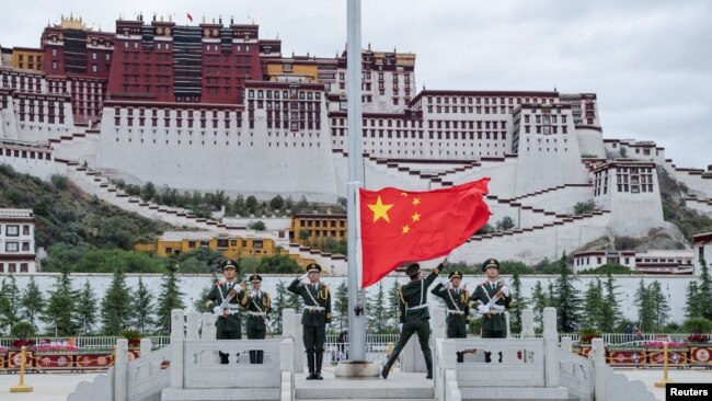 中国军人在西藏拉萨布达拉宫前升国旗庆祝中共建党96周年。（2017年7月1日）