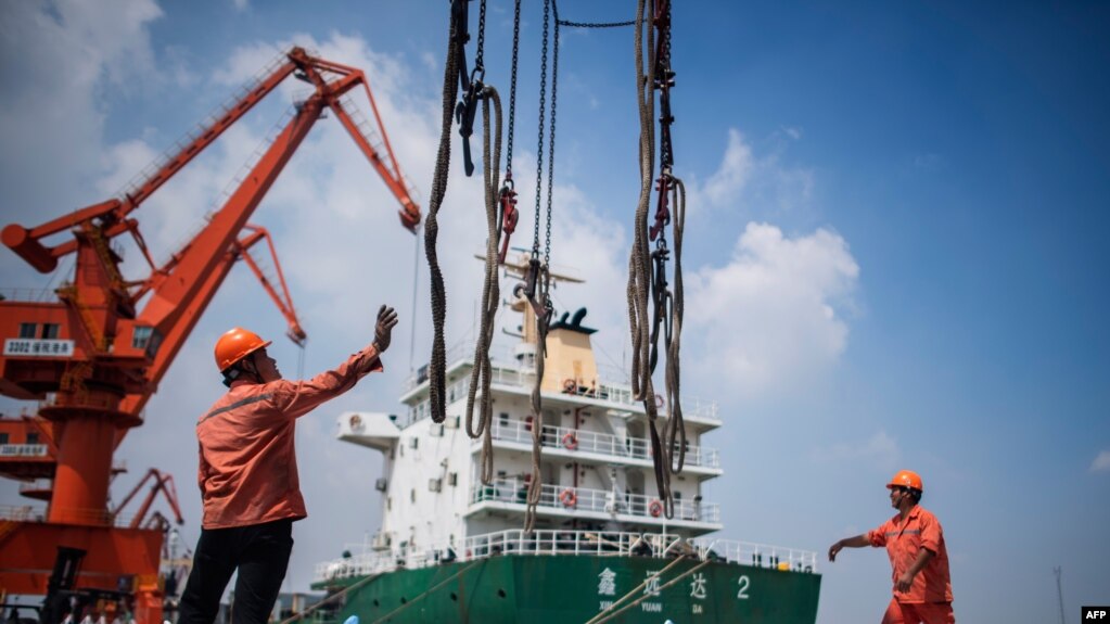 2018年8月7日，工人在中国江苏省张家港的一个港口卸下化学品。