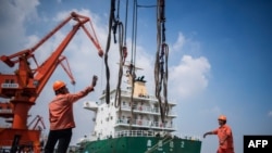 2018年8月7日，工人在中国江苏省张家港的一个港口卸下化学品。
