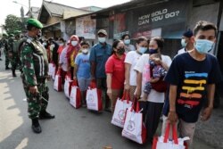 Warga mengenakan masker di tengah pandemi COVID-19, antre untuk menerima bantuan yang diberikan oleh Presiden Indonesia di Jakarta, 16 Juli 2021. (REUTERS/Willy Kurniawan/File Photo)