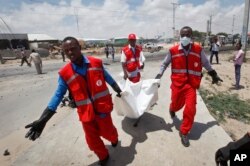 Somali Red Crescent workers carry away the body of a Somali civilian after an attack on a European Union military convoy in the capital Mogadishu, Somalia, Oct. 1, 2018.