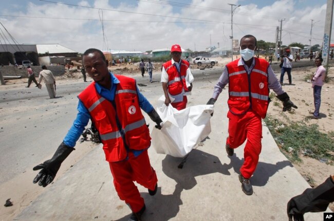 Somali Red Crescent workers carry away the body of a Somali civilian after an attack on a European Union military convoy in the capital Mogadishu, Somalia, Oct. 1, 2018.