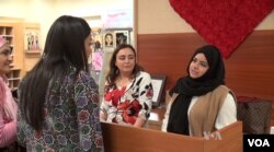 Graduate student Alyaa Al-Maadeed (right) helped organize the pop-up shop to help refugee women sell their handcrafted goods.