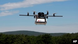 FILE - A prototype drone is seen carrying a parcel for delivery.