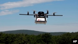 FILE - A prototype drone is seen carrying a parcel for delivery.