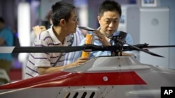 Para pengunjung memperhatikan helikopter drone di sebuah pameran di Beijing, China, 18 Mei 2018. 