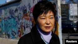 South Korean President Park Geun-hye looks at the exhibition 'DMZ-Gruenes Band' during a visit to the East Side Gallery in Berlin, March 27, 2014. 