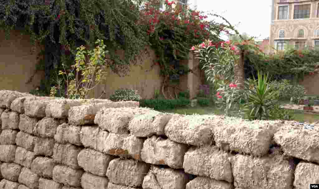 Extra mud bricks make a temporary wall in the garden. (E. Arrott/VOA)