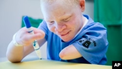 FILE - Albino Emmanuel Festo Rutema receives occupational therapy Aug. 27, 2015, at Shriners Hospital for Children in Philadelphia.