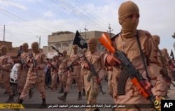 FILE -- In this photo released April 25, 2015, by an extremist militant website, which has been verified and is consistent with other AP reporting, young boys known as the "lion cubs" hold rifles during a parade after graduating from a religious school in Tal Afar, Iraq.