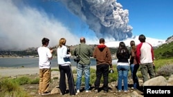 FILE - Local residents watch a column of smoke and ash rise from the Copahue volcano, located on the Chile-Argentina border, December 22, 2012. 