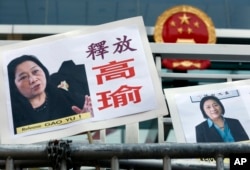 FILE - Pictures of jailed veteran Chinese journalist Gao Yu are displayed by protesters outside Chinese central government's liaison office in Hong Kong, Apr 17, 2015.