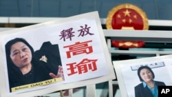 Pictures of jailed veteran Chinese journalist Gao Yu are displayed by protesters outside Chinese central government's liaison office in Hong Kong Friday, April 17, 2015.