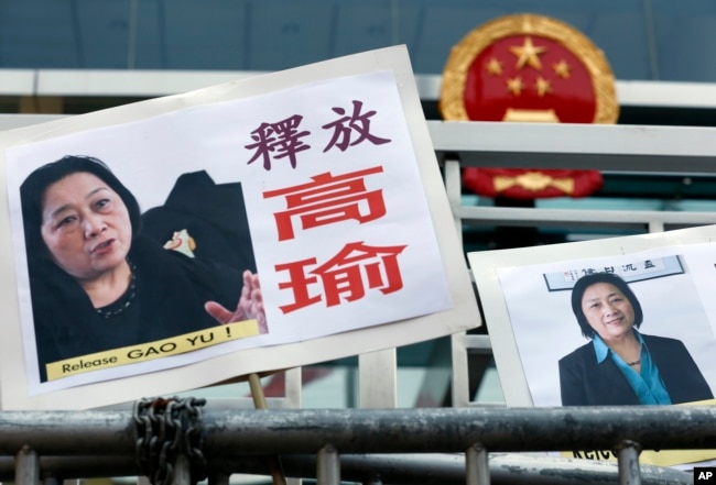 FILE - Pictures of jailed veteran Chinese journalist Gao Yu are displayed by protesters outside Chinese central government's liaison office in Hong Kong, Apr 17, 2015.